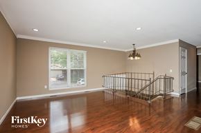 Florissant house for rent - an empty living room with a staircase and a large window