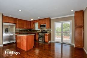 Florissant house for rent - a kitchen with wooden cabinets and stainless steel appliances and a window