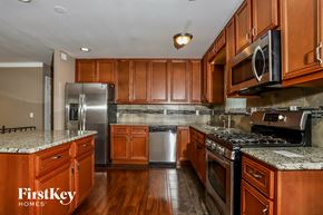 Florissant house for rent - a kitchen with wood cabinets and stainless steel appliances and granite counter tops