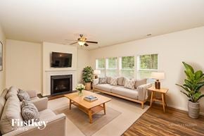 Denver house for rent - A living room with a fireplace, a couch, a chair, a coffee table, and a potted plant.
