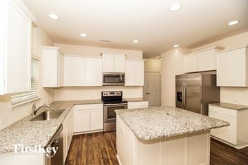 Denver house for rent - A kitchen with white cabinets and granite countertops.