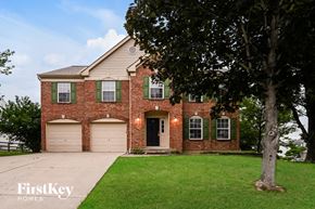 Florence house for rent - A brick house with green shutters and a tree in front.