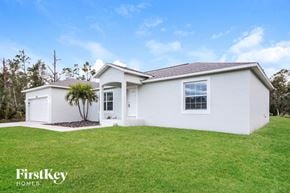 Port Charlotte house for rent - A white house with a brown roof and a tree in front of it.