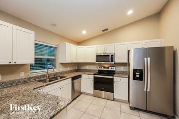 Port Charlotte house for rent - A kitchen with a stainless steel refrigerator and a granite countertop.