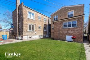 Chicago house for rent - a view of two brick apartment buildings with a yard and grass