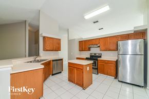 Palmetto house for rent - an empty kitchen with wooden cabinets and stainless steel appliances
