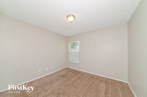 Palmetto house for rent - a spacious room with carpet and a window