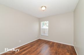 Palmetto house for rent - a bedroom with hardwood floors and white walls and a window