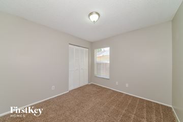 Palmetto house for rent - a spacious living room with carpet and a large window