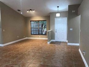 Palmetto house for rent - an empty living room with a white door