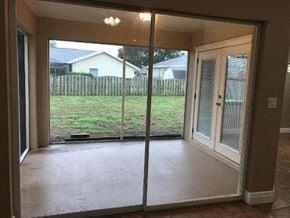 Palmetto house for rent - a living room with a sliding glass door and a yard