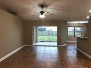 Palmetto house for rent - a empty living room with a ceiling fan