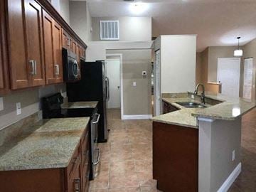 Palmetto house for rent - a kitchen with a sink and a refrigerator