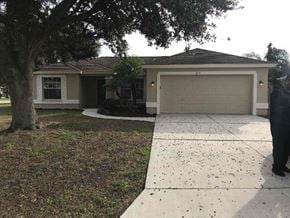 Palmetto house for rent - a house with a driveway and a garage door