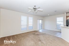 Fort Worth house for rent - an empty living room with a ceiling fan and a window