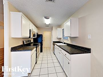 Arlington house for rent - a white kitchen with white cabinets and black counter tops