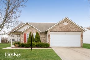 Indianapolis house for rent - A brick house with a red door and a garage door.