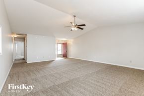 Indianapolis house for rent - A spacious room with a carpeted floor and a ceiling fan.