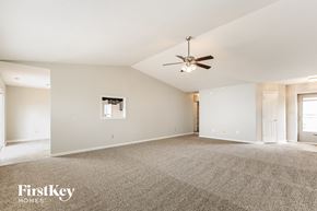 Indianapolis house for rent - A spacious room with a carpeted floor and a ceiling fan.