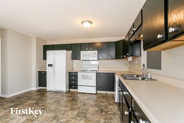 Indianapolis house for rent - A kitchen with black cabinets and white appliances.