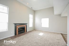 Indianapolis house for rent - A spacious living room with a fireplace and two windows.