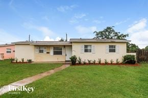 Sunrise house for rent - a home with a green lawn and a fence