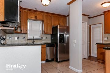 Sunrise house for rent - a kitchen with stainless steel appliances and wooden cabinets