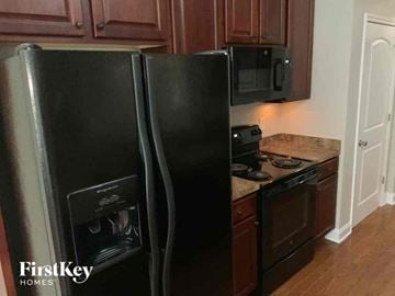 Flowery Branch house for rent - a kitchen with a black refrigerator and a stove
