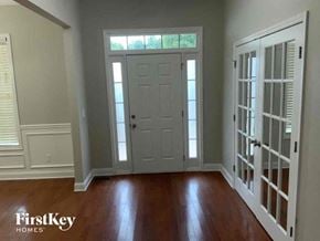 Flowery Branch house for rent - an empty living room with a white door and wood floors