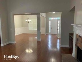 Flowery Branch house for rent - an empty living room with wood floors and a fireplace