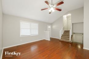 Kansas City house for rent - A room with a wood floor and a ceiling fan.