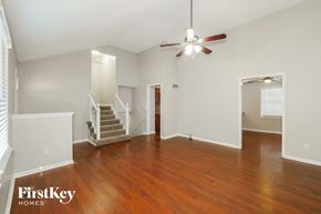 Kansas City house for rent - A spacious room with wooden floors and a ceiling fan.
