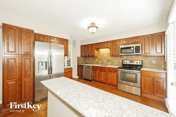 Kansas City house for rent - A kitchen with wooden cabinets and a refrigerator.