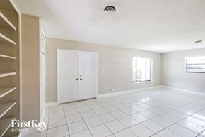 Sunrise house for rent - an empty living room with a white tile floor and a closet