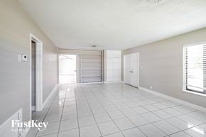 Sunrise house for rent - an empty living room with a tiled floor and a closet