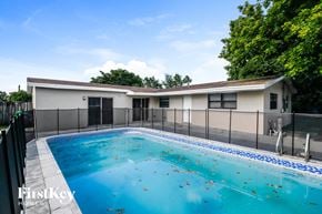 Sunrise house for rent - a pool with a house in the background