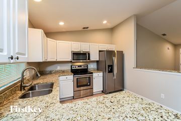 Englewood house for rent - A kitchen with white cabinets and a granite countertop.