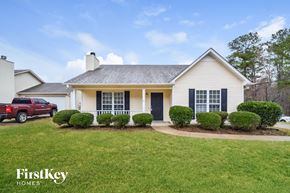 Birmingham house for rent - A white house with a black door and windows is shown with a grassy front yard.