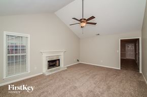Birmingham house for rent - A room with a fireplace and a ceiling fan.