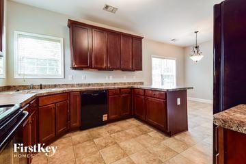 Flowery Branch house for rent - A kitchen with brown cabinets and a black dishwasher.