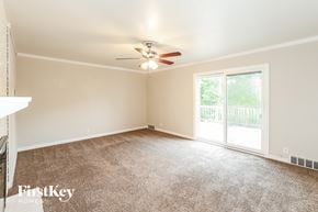 Kansas City house for rent - A room with a carpet floor and a ceiling fan.