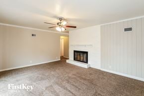 Kansas City house for rent - A room with a fireplace and a ceiling fan.