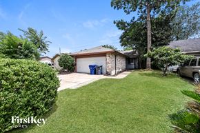 Houston house for rent - A house with a garage and a car is shown in the image.