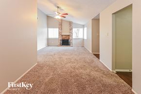 Houston house for rent - A room with a fireplace and a fan on the ceiling.