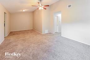 Houston house for rent - A spacious room with a ceiling fan and carpeted floor.