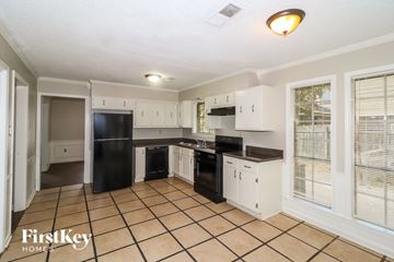 Memphis house for rent - A kitchen with black appliances and white cabinets.