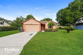 Lakeland house for rent - a single story home with a garage and a green lawn