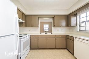 Lakeland house for rent - an empty kitchen with white appliances and brown cabinets