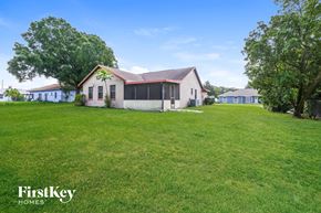 Lakeland house for rent - a white house with a large yard and some trees