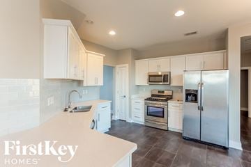 Olive Branch house for rent - a white kitchen with stainless steel appliances and white cabinets